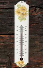 Vertical Shot Of A Decorative Thermometer With Flowers On A Wooden Wall