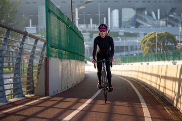 Evening workout of a woman on a bike. Play sports in the city. Yacht Bridge St. Petersburg.