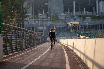 Evening workout of a woman on a bike. Play sports in the city. Yacht Bridge St. Petersburg.