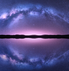 Wall Mural - milky way arch reflected in water. night landscape with bright arched milky way, purple sky with sta