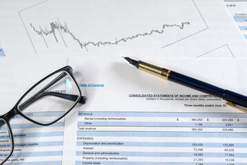 Financial budget statement with eyeglasses and pen. Checking financial report