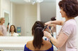© diignat - Beautiful young woman getting haircut by hairdresser in the beauty salon. Hair stylist in working process