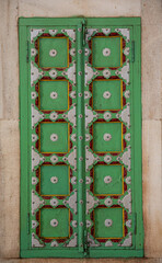 Canvas Print - Vertical shot of a green door in Indian-style decorations