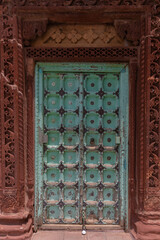 Wall Mural - Vertical shot of an old green door in Indian-style decorations