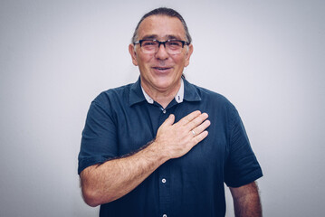 an adult man makes a gesture of thanks and greets with his hand on his chest