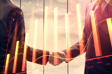 Double exposure of forex graph hologram and handshake of two men. Stock market concept.