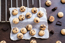 Top View Of Mini Cookies On Parchment Paper With Sliced Chocolate Bars