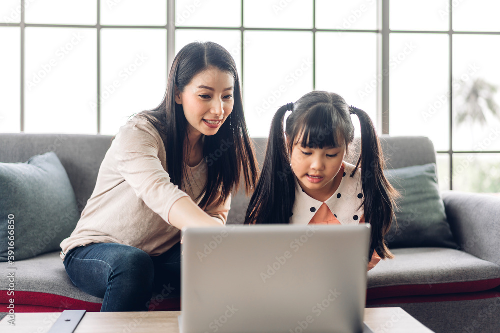 Mother and asian kid little girl learning and looking at laptop ...