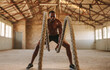 © Jacob Lund - Muscular man working out with battle ropes