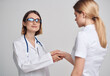 © SHOTPRIME STUDIO - Professional doctor woman and patient shake hands on a light background