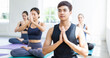 © winnievinzence - Group of diversity or multiethnic young sporty people sitting on mat and learning yoga in fitness class. meditation and relaxing body. health club and wellness lifestyle concept
