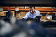 © Dusan Petkovic - Smiling bearded boss standing in warehouse, holding tablet and checking on supplies on shelf.