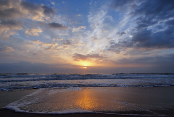 Colorful orange and blue sunrise over ocean on St Augustine Beach, Florida.