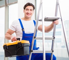 Wall Mural - Young repairman climbing ladder at construction site