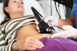 Closeup of female abdomen during professional ultrasonic fat cavitation procedure in cosmetology clinic