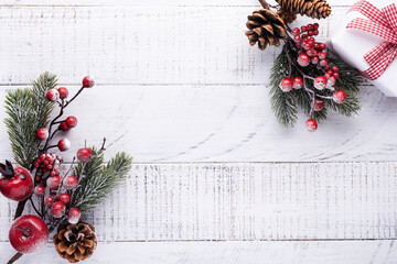 Сhristmas background with fir branches,pinecones and berries on the old  white wooden board. Top view.