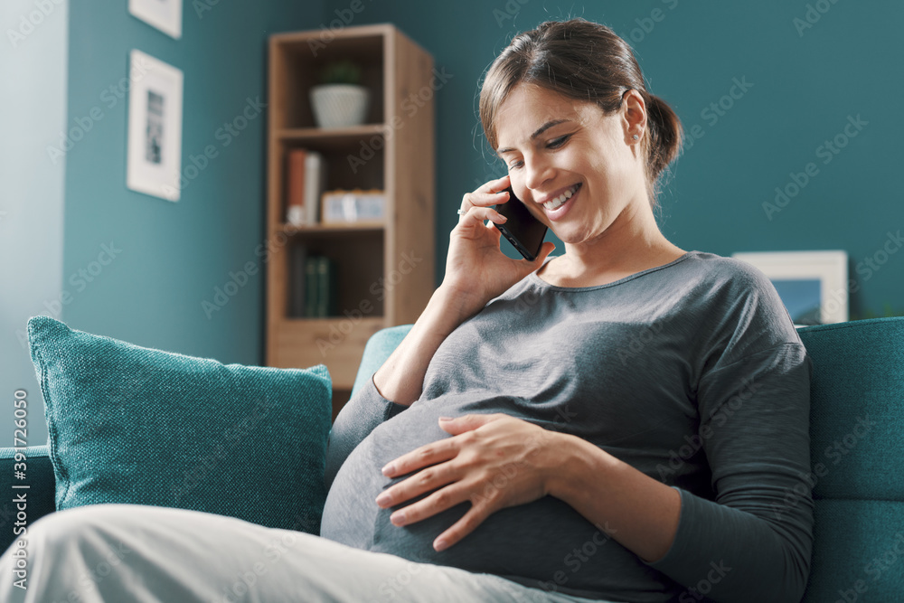 Happy pregnant woman talking on the phone