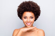 Close up photo of charming afro american girl enjoy pampering tone concealer skincare treatment make skin soft pure shiny soft fresh perfect ideal touch palm chin isolated grey color background