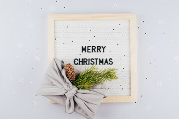 Wall Mural - Christmas eco-friendly gift box furoshiki. Lightbox with text Merry Christmas. Zero waste concept