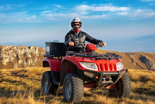 A Man On A Quad Bike In The Mountains. 