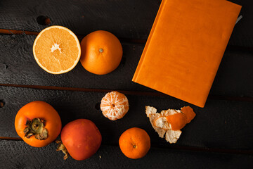 Wall Mural - Orange persimmon and tangerine on black background