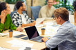 © Friends Stock - Teamwork. Group of young multiracial people sitting at the table in board room in the modern office, using modern technologies and working on project together