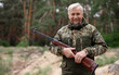 © freeograph - Happy Hunter Old Man in Camouflage with Shotgun.