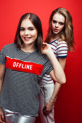 Wall Mural - two best friends teenage girls together having fun, posing emotional on red background, lifestyle people concept