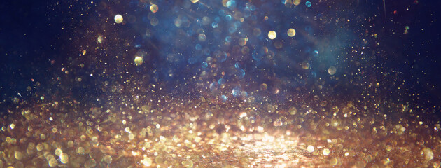 background of abstract glitter lights. gold, blue and black. de focused