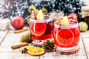 Wall Mural - Christmas mulled red wine with spices and dried oranges on a rustic wooden table. Traditional hot drink for Christmas in the United States