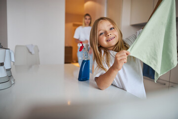 Wall Mural - Happy cheerful daughter helping clean apartment her mother at the weekend