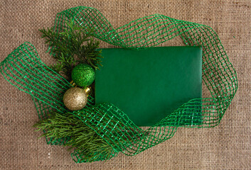  New Year and Christmas composition, green greeting card on burlap background, stylish. Flat lay, copy space, top view