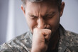 Soldier in military uniform crying with closed eyes