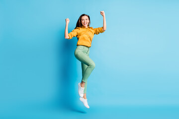 Poster - Full size photo of cool pretty brunette lady jump hands fists wear shirt trousers sneakers isolated on teal color background