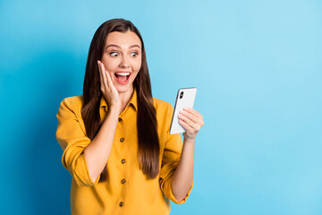 Poster - Portrait of impressed cute brunette lady watch telephone wear yellow cloth isolated on teal color background