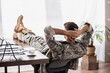 © LIGHTFIELD STUDIOS - Back view of soldier in military uniform resting in office