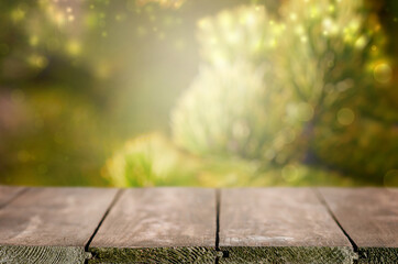 Wall Mural - Empty wooden table in front of abstract green blurred background. Wood table top on blur background. Mock up for display of product