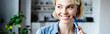 © LIGHTFIELD STUDIOS - young blonde woman holding pen and smiling, horizontal banner
