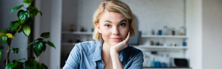 Wall Mural - young blonde woman leaning chin on hand, horizontal banner