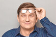 © Andrei Korzhyts - Portrait of happy man holding glasses on forehead, looking at you