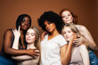 © iordani - young pretty african and caucasian women posing cheerful together on brown background, lifestyle diverse nationality people concept