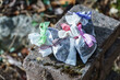 Small fabric and tulle sachet filled with lavender and closed with colored ribbons, placed on a pile of concrete stone tiles