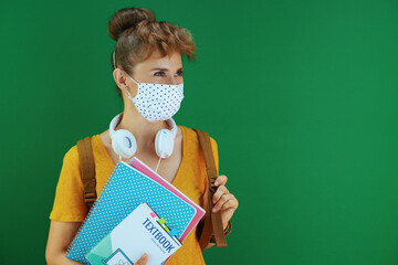 Wall Mural - young learner woman in yellow shirt on green background