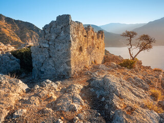 sunrise lights on the walls of ruins of antique church and island in the morning