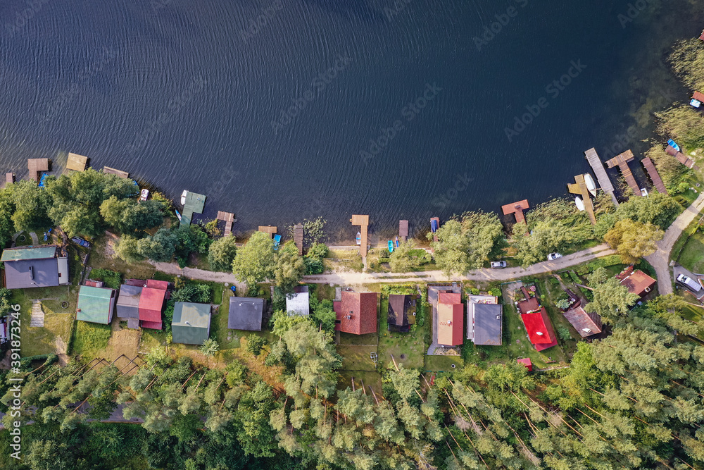 Drone view of summer cottages over Narie lake of Ilawa Lake District in Kretowiny, small village in Warmia Mazury region of Poland - obrazy, fototapety, plakaty 