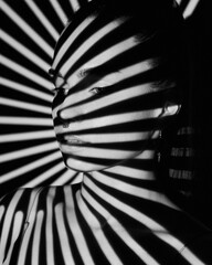 portrait of woman in a shadow stripe. young girl portrait with a shadow pattern on the face in the f