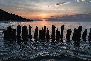 Wall Mural - Sunset over breakwater on a beach in Debki resort village on the Baltic Sea coast in Pomerania region of Poland