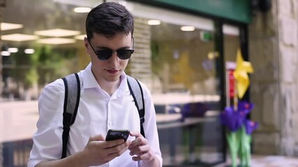 Caucasian man in white shirt and sunglasses talking on the phone. Sunny day