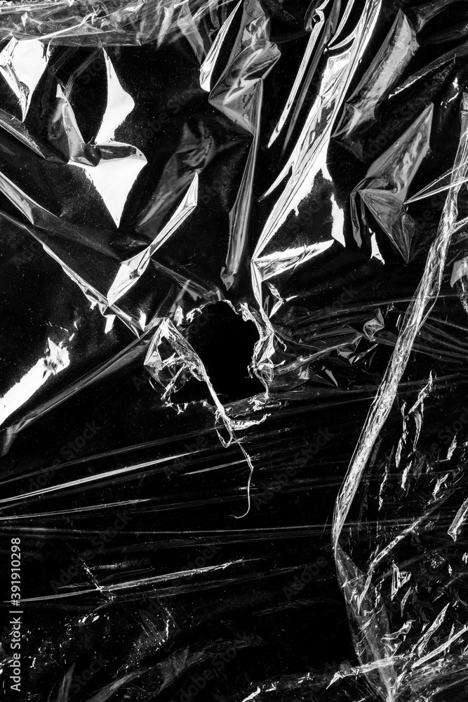 Wrinkled plastic wrap texture on a black background - obrazy, fototapety, plakaty 