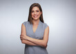 © Yuriy Shevtsov - Business woman in gray dress posing with crossed arms.
